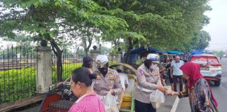 Polwan Polres Jombang membagikan ratusan nasi bungkus kepada juru parkir dan tukang becak yang dibeli dari sejumlah pedagang kaki lima di Jalan Protokol Kota Jombang.