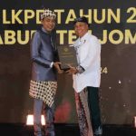 Pj Bupati saat menerima penghargaan Opini WTP