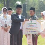 PJs Bupati Sidoarjo, Muhammad Isa Ansori memberikan penghargaan kepada santri berprestasi saat peringatan HSN 2024.