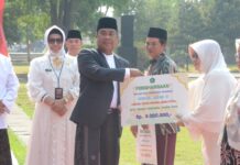 PJs Bupati Sidoarjo, Muhammad Isa Ansori memberikan penghargaan kepada santri berprestasi saat peringatan HSN 2024.