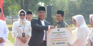 PJs Bupati Sidoarjo, Muhammad Isa Ansori memberikan penghargaan kepada santri berprestasi saat peringatan HSN 2024.