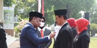 Pjs Bupati Sidoarjo, Isa Ansori menyematkan pin tanda kehormatan dari Presiden saat upacara Hari Pahlawan.