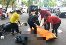 Petugas mengevakuasi korban kecelakaan di jalan raya Tunggorono, Jombang.