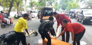 Petugas mengevakuasi korban kecelakaan di jalan raya Tunggorono, Jombang.