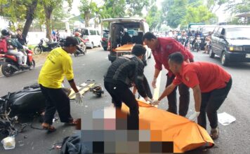 Petugas mengevakuasi korban kecelakaan di jalan raya Tunggorono, Jombang.