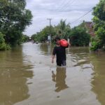 Warga Saat melintasi banjir di Dusun Bulak, Desa Jombok, Kesamben, Jombang