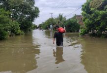 Warga Saat melintasi banjir di Dusun Bulak, Desa Jombok, Kesamben, Jombang