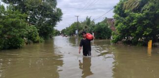 Warga Saat melintasi banjir di Dusun Bulak, Desa Jombok, Kesamben, Jombang