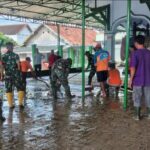 Warga bersama TNI dan Polisi membersihkan sisa banjir di Tarik Sidoarjo.