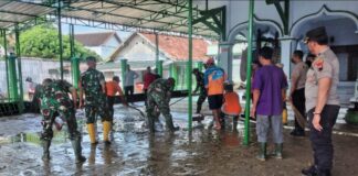 Warga bersama TNI dan Polisi membersihkan sisa banjir di Tarik Sidoarjo.