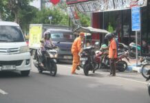 Juru parkir (Jukir) di Jombang saat menerima jasa./bongkah.id/Karimatul Maslahah/