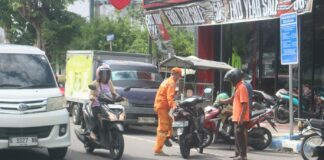 Juru parkir (Jukir) di Jombang saat menerima jasa./bongkah.id/Karimatul Maslahah/