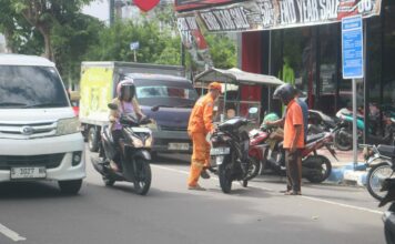 Juru parkir (Jukir) di Jombang saat menerima jasa./bongkah.id/Karimatul Maslahah/