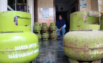 Pedagang di Jombang saat menunjukkan elpiji 3 Kg yang dijualnya./bongkah.id/Karimatul Maslahah/