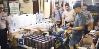 Polisi mengamankan barang bukti minuman keras saat penggerebekan rumah produksi miras oplosan di Jetis, Mojokerto.