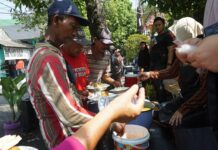 Tukang becak dan pengguna jalan antre mengambil sarapan gratis yang disediakan warga lingkungan Jalan Dokter Setiabudi Jombang. Bongkah.id/Karimatul Maslahah/