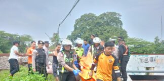 Petugas mengevakuasi korban siswi sd di Kota Mojokerto yang meninggal tertabrak KA Sancaka, Selasa (27/5/2025).