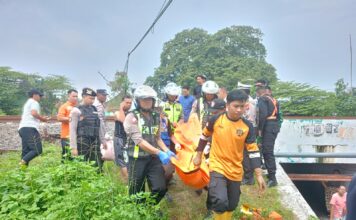 Petugas mengevakuasi korban siswi sd di Kota Mojokerto yang meninggal tertabrak KA Sancaka, Selasa (27/5/2025).