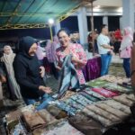Anggota DPR RI Komisi VI Sadarestuwati (kiri) dan Rieke Diah Pitaloka membeli kain batik saat bulan Karno di Balai Desa Plandi Kabupaten Jombang, Rabu (11/6/2025) malam. Bongkah.id/Karimatul Maslahah/