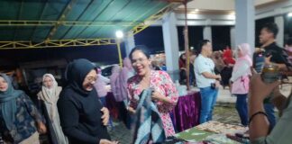 Anggota DPR RI Komisi VI Sadarestuwati (kiri) dan Rieke Diah Pitaloka membeli kain batik saat bulan Karno di Balai Desa Plandi Kabupaten Jombang, Rabu (11/6/2025) malam. Bongkah.id/Karimatul Maslahah/