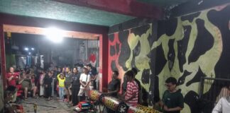 WNA asal Spanyol berjoget riang sambil diiringi musik patrol di kawasan Wetan Pasar Tanjung, Kelurahan Kepatihan, Kecamatan Kaliwates, Jember, pada Rabu malam (11/6/2025). Bongkah.id/Muhammad Hatta/