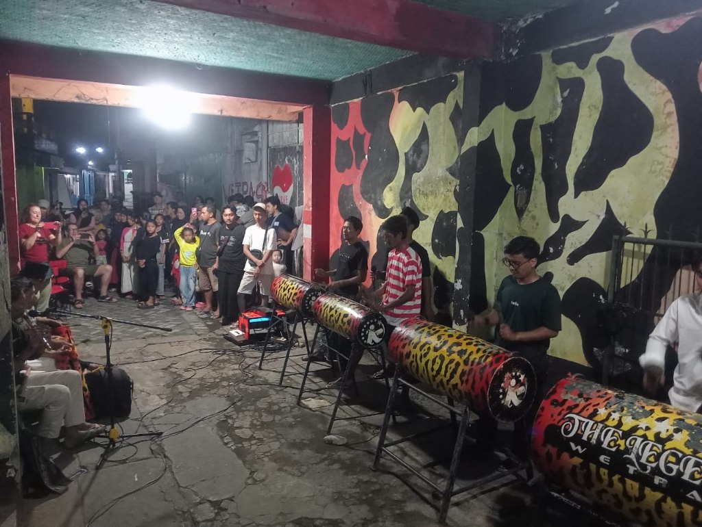 1000812033 WNA asal Spanyol berjoget riang sambil diiringi musik patrol di kawasan Wetan Pasar Tanjung, Kelurahan Kepatihan, Kecamatan Kaliwates, Jember, pada Rabu malam (11/6/2025). Bongkah.id/Muhammad Hatta/