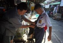 Ismail saat menerima pelanggan jahit seragam di pasar tanjung anyar, Kota Mojokerto./bongkah.id/Karimatul Maslahah/