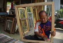 Romy saat mengamplas bingkai kayu di halaman tokonya./bongkah.id/Karimatul Maslahah/