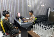 petugas saat melakukan pemeriksaan terhadap dua remaja penjual miras di kota Mojokerto./bongkah.id/Karimatul Maslahah/