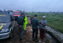 Polisi saat olah TKP bayi tenggelam di saluran air Jember.