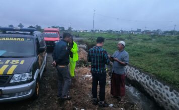 Polisi saat olah TKP bayi tenggelam di saluran air Jember.