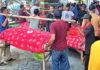 Warga Desa Pagerngumbuk Sidoarjo mengarak tumpeng dan hasil bumi di atas amben bambu saat tradisi ruwat desa.