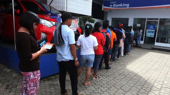 Antrian masyarakat yang hendak bertransaksi di ATM.